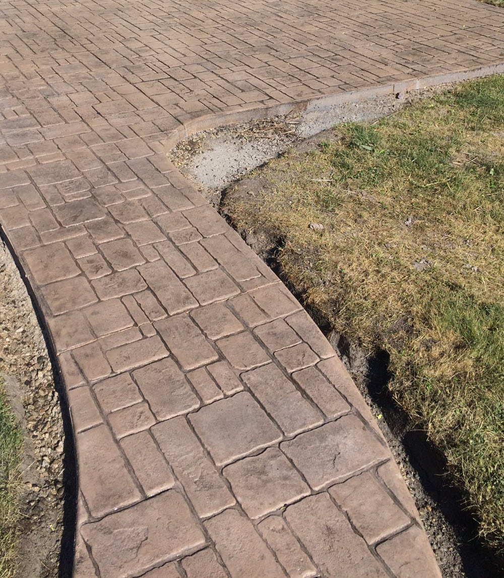 Cobblestone-pattern stamped concrete walkway & patio, installed by Creative Concrete
